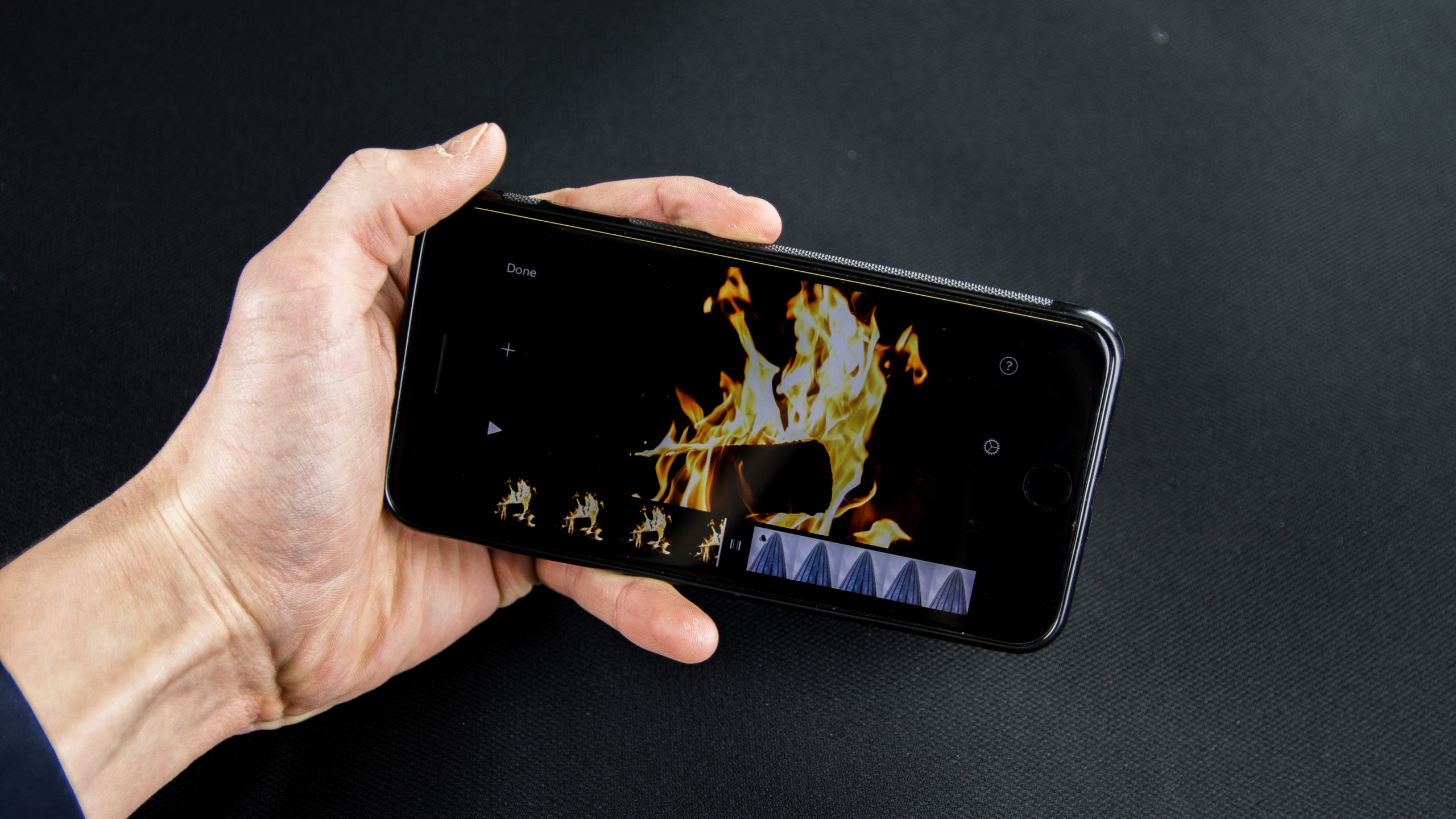 Telefon w ręce z odpaloną aplikacją do montowania filmów na IOS iMovie